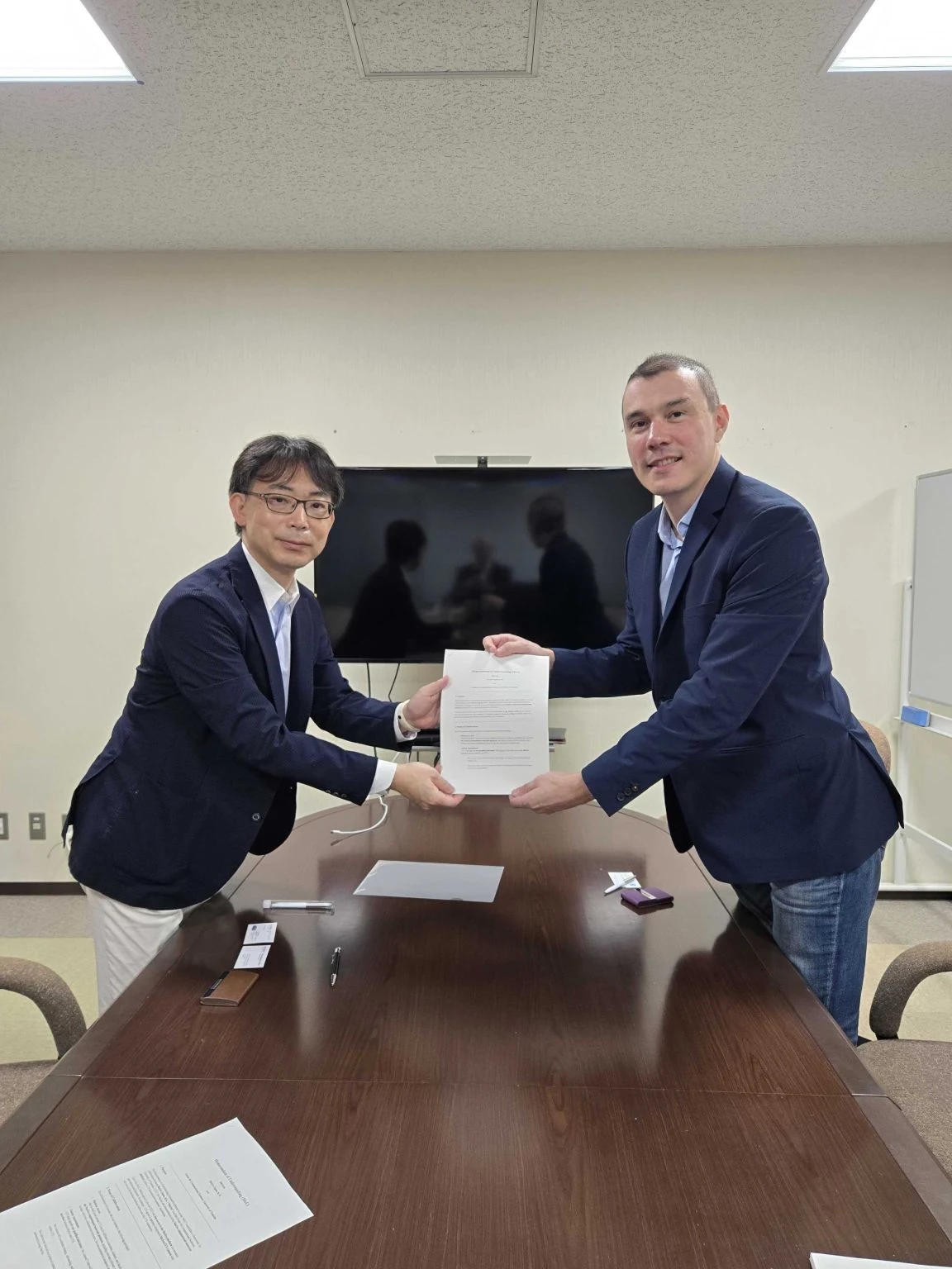 Presenting the signed memorandum of understanding at the University of Tsukuba